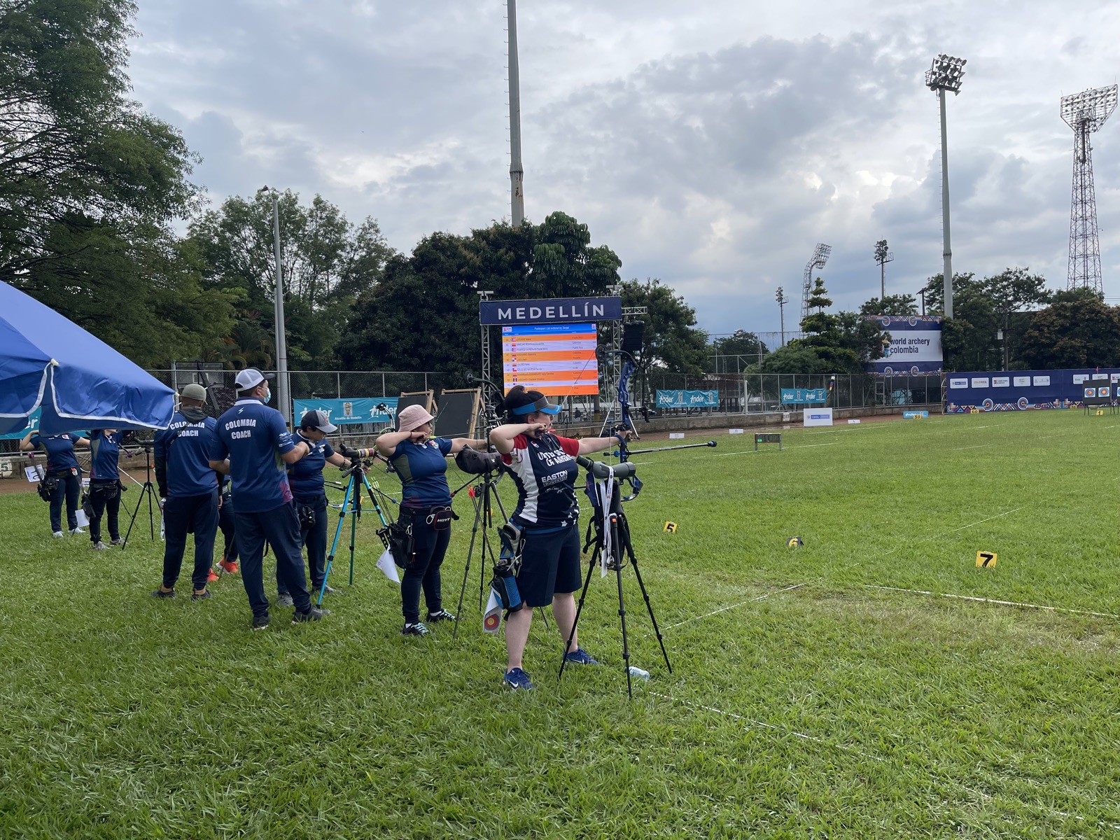 Archers practicing on the field at an outdoor archery tournament