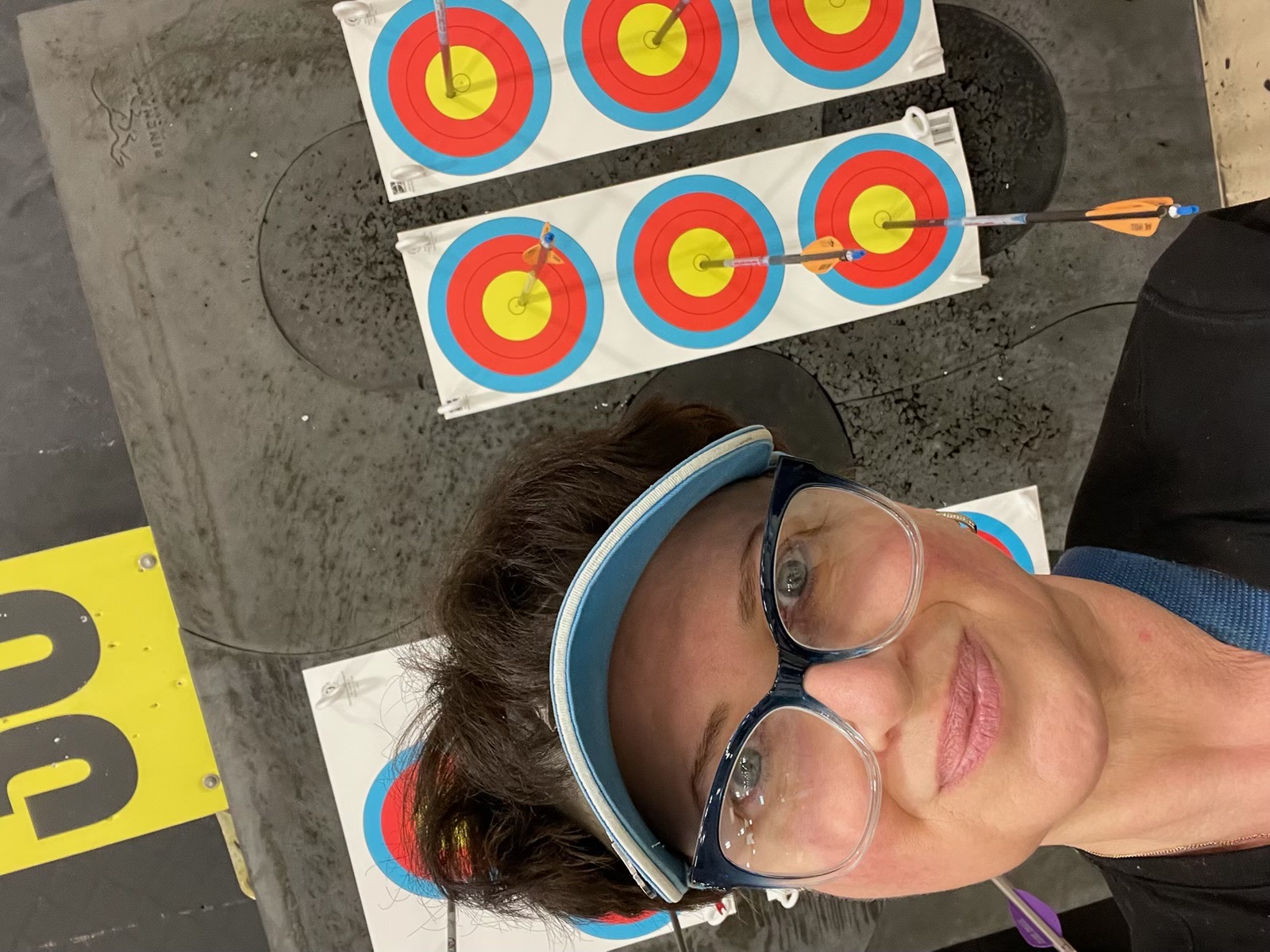 Archery coach Marianna Finkel with arrows in the gold behind her